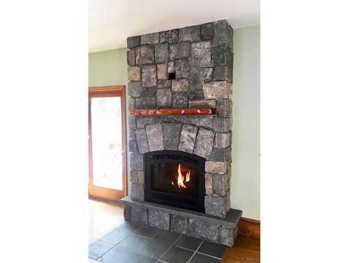 Granite Fireplace with Sculpted Sapele Mantle. Stone sourced from Champlain Stone in Whitehall, New York. Mantle wood sourced from Northern Hardwoods.